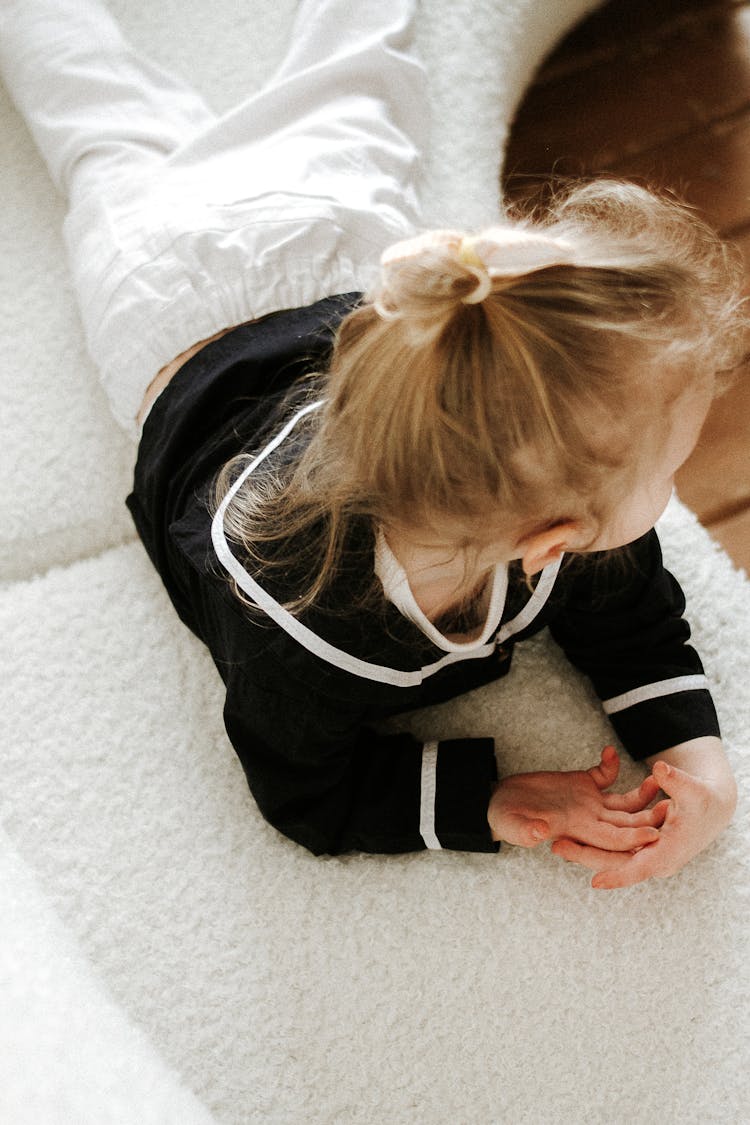 Photo Of A Blond Child Lying On A White Sofa