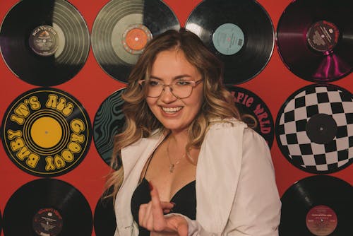 Woman Posing with Vinyl Disks on Wall behind