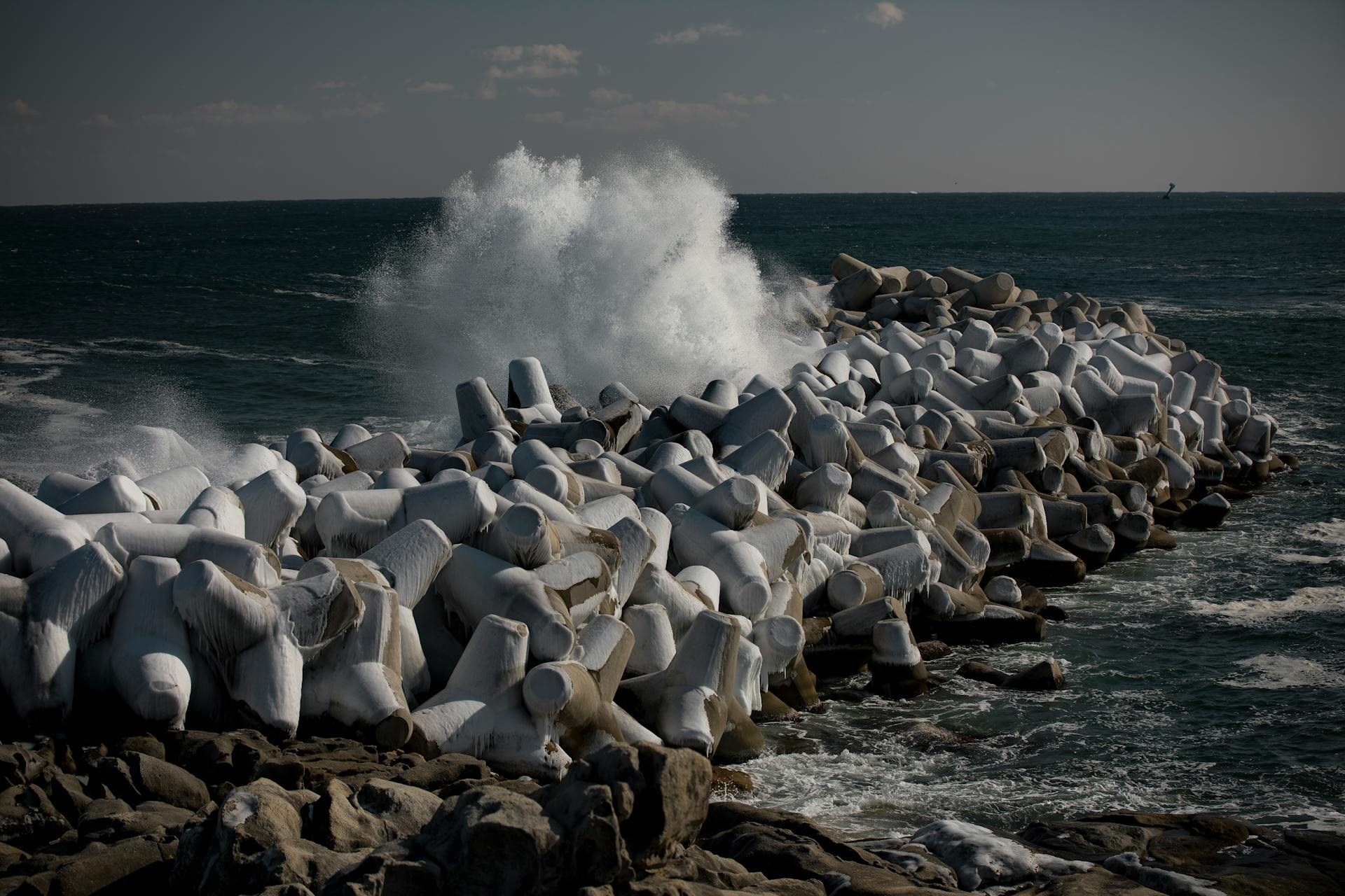Powerful waves crashing against a breakwater, showcasing marine forces in Goseong-gun, South Korea.