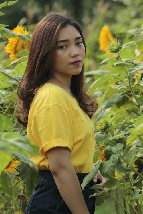 Woman in a Yellow T-shirt in a Sunflower Field