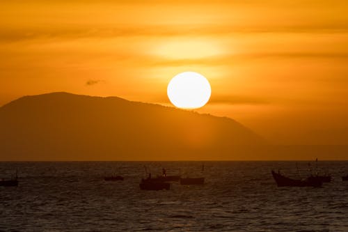 Silhouettes of Boats on the Sea during Golden Hour