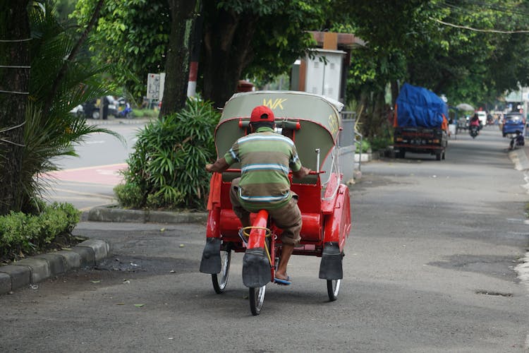 A Man Driving A Rickshaw 