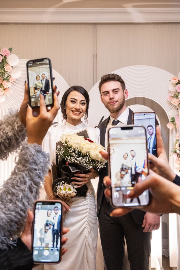 Invitados sosteniendo sus celulares para fotografiar a los novios durante la ceremonia