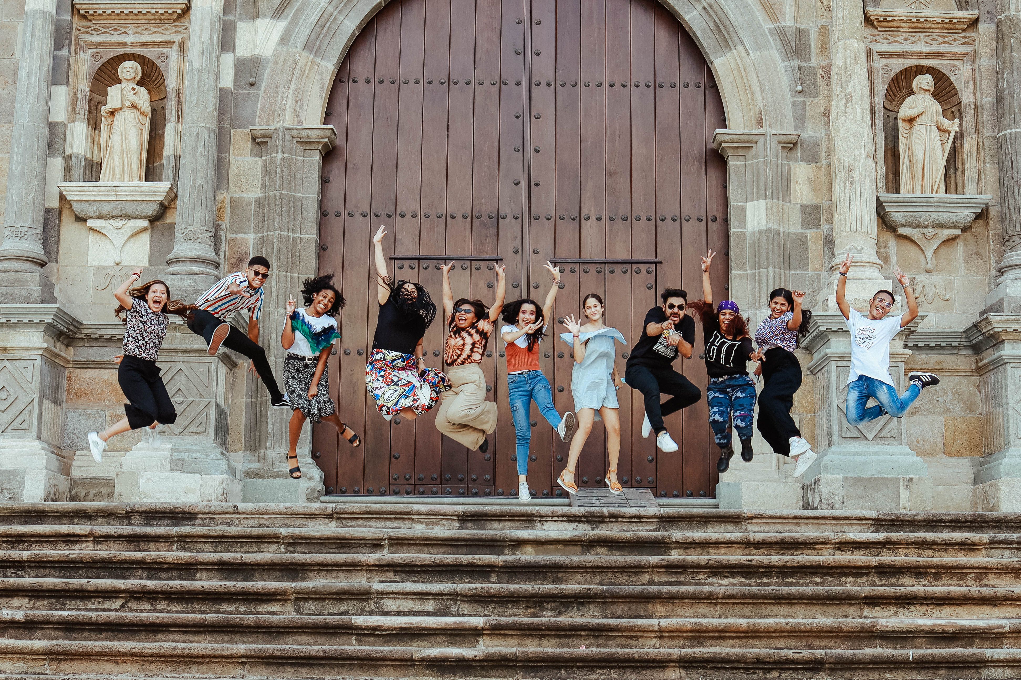 Photo of Young People Smiling and Posing in front of Entrance Door to a ...