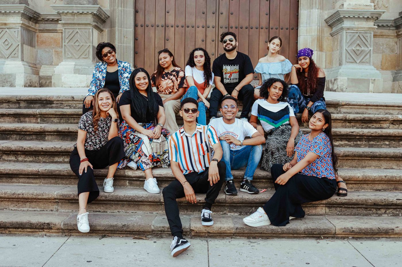 The whole team sitting together on a flight of stone steps — photo by Luis Quintero on Pexels