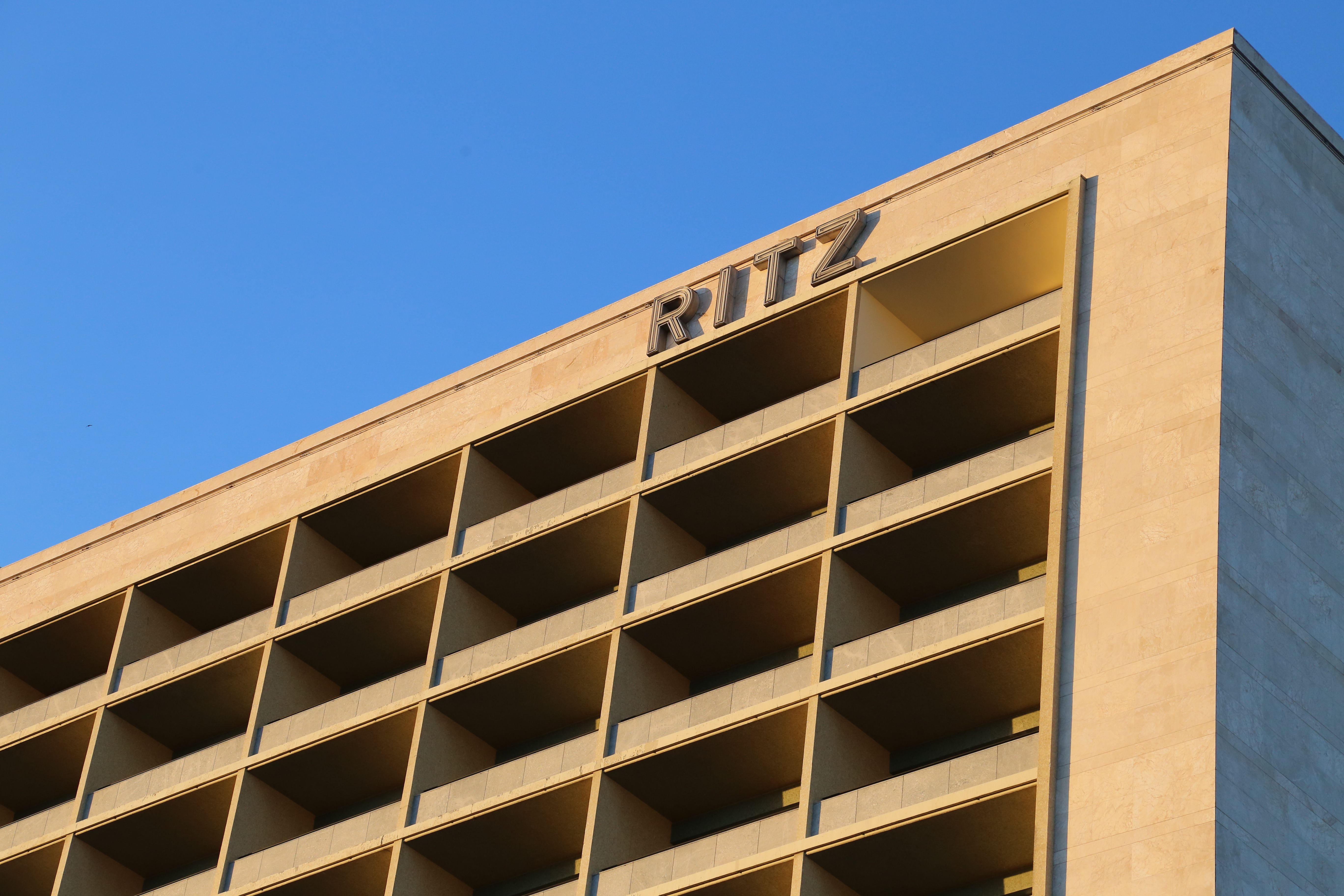 Upscale Ritz hotel facade in Lisbon captured during a golden sunset, showcasing modern urban architecture.