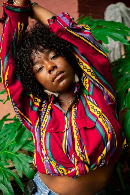 Expressive portrait of a woman in a colorful blouse, posing confidently.