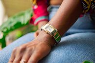 Close-up of a stylish wristwatch on a person's arm, wearing a denim outfit.