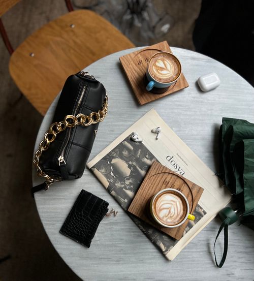 Free Aerial shot of a stylish coffee scene with coffee, a bag, and a newspaper on a table. Stock Photo