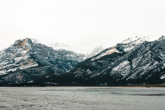 Stunning view of snow-capped mountains and lake in Jasper, Alberta during winter.