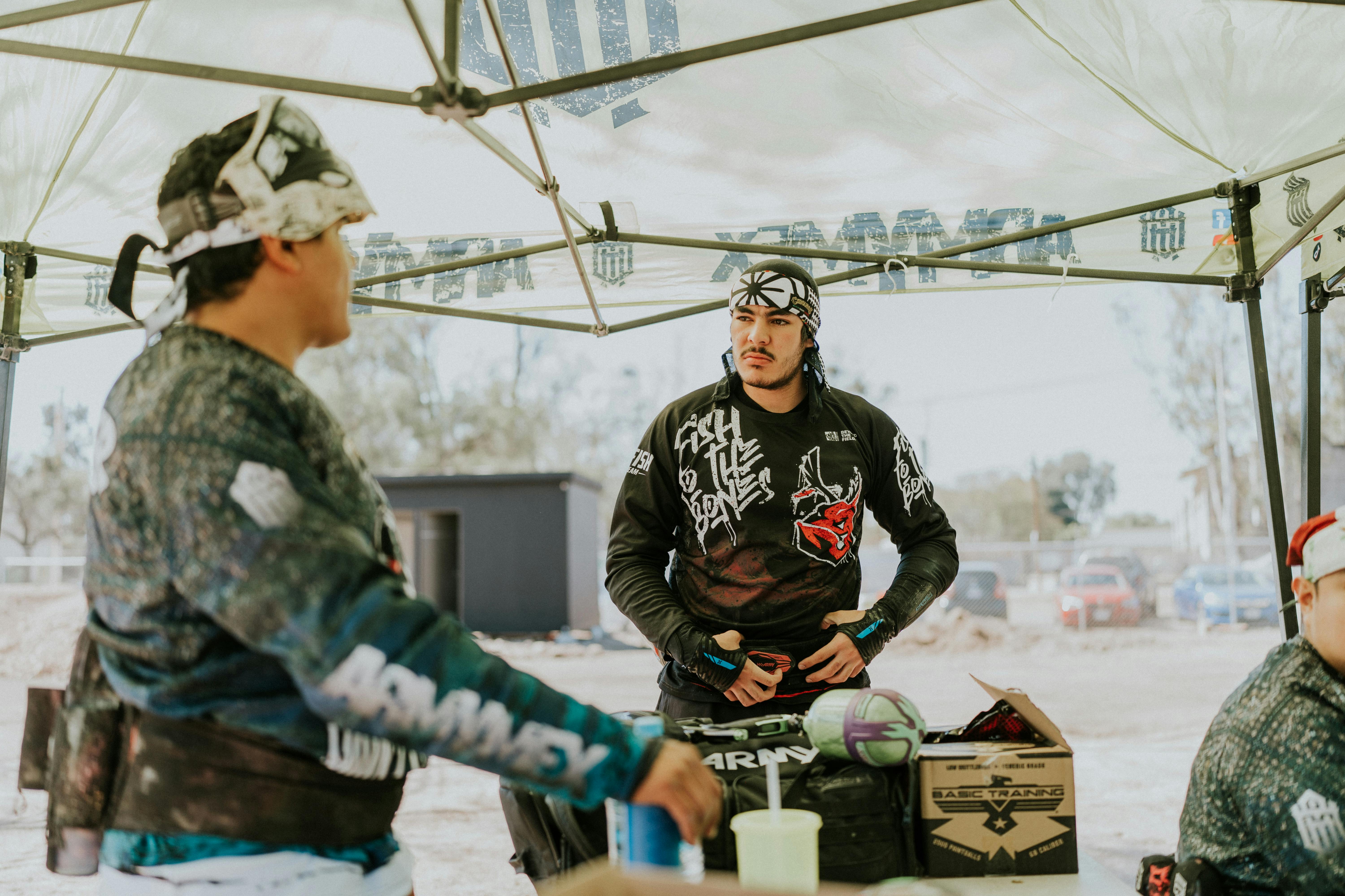 Men in paintball gear preparing for a game under a tent, showcasing teamwork and focus. Prescription Goggle Inserts - Men in paintball gear preparing for a game under a tent, showcasing teamwork and focus.