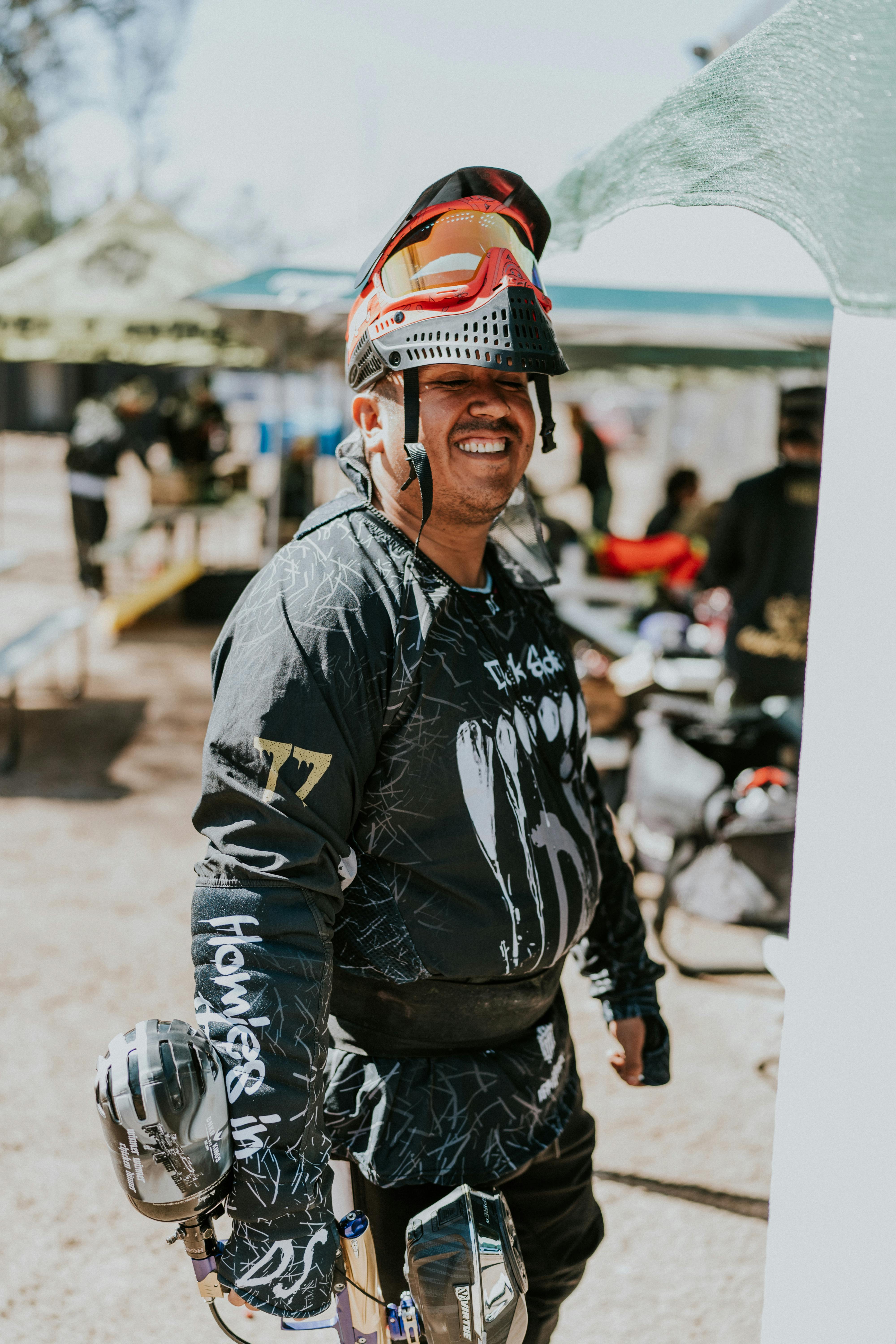 Un homme heureux avec un équipement de paintball et un masque de protection à l'extérieur, prêt à l'action. Prescription Goggle Inserts - A happy man with paintball gear and protective mask outdoors, ready for action.