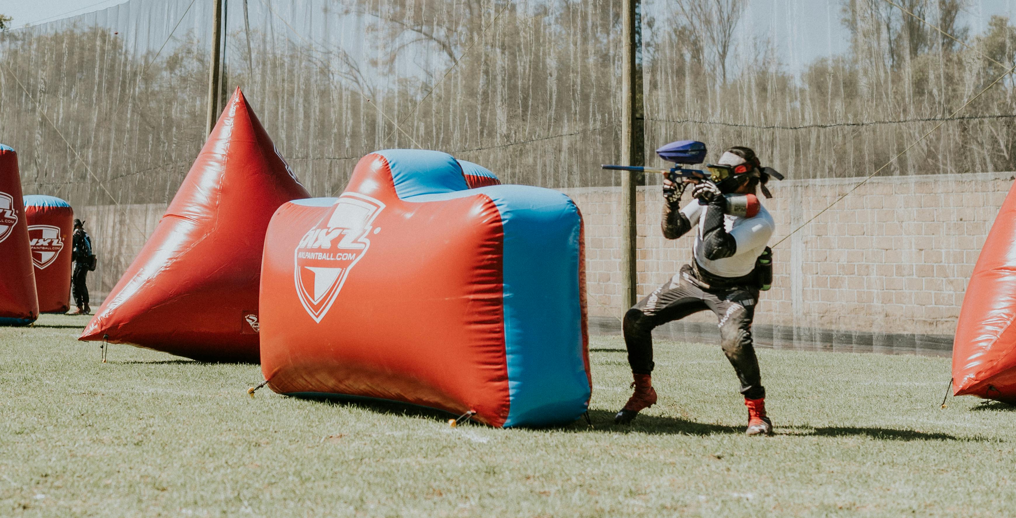 Joueur visant lors d'un match de paintball intense en extérieur. Prescription Goggle Inserts - Player aiming during an intense paintball match outdoors.