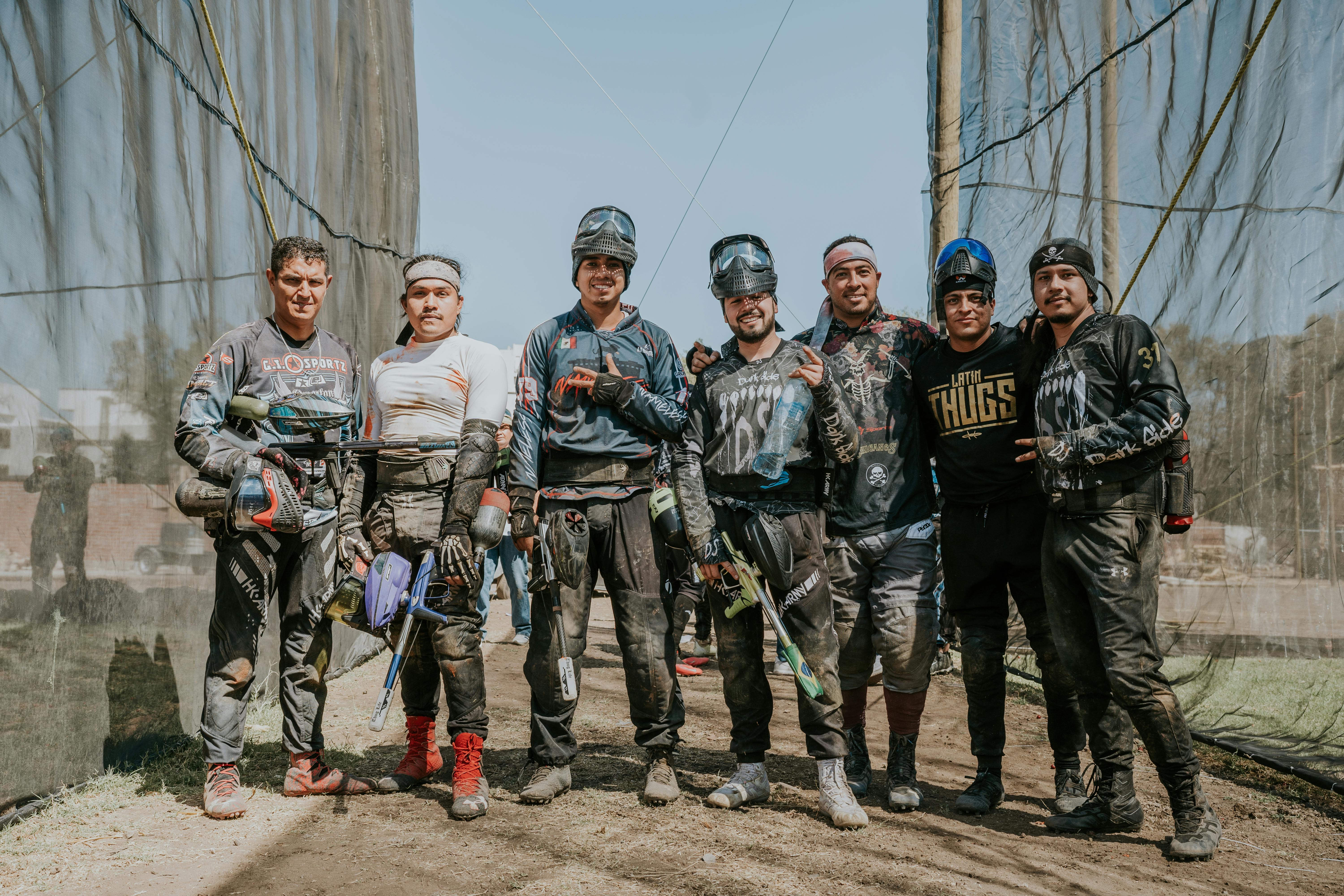 A group of men enjoying an outdoor paintball game in gear, smiling for the camera. Prescription Goggle Inserts - A group of men enjoying an outdoor paintball game in gear, smiling for the camera.