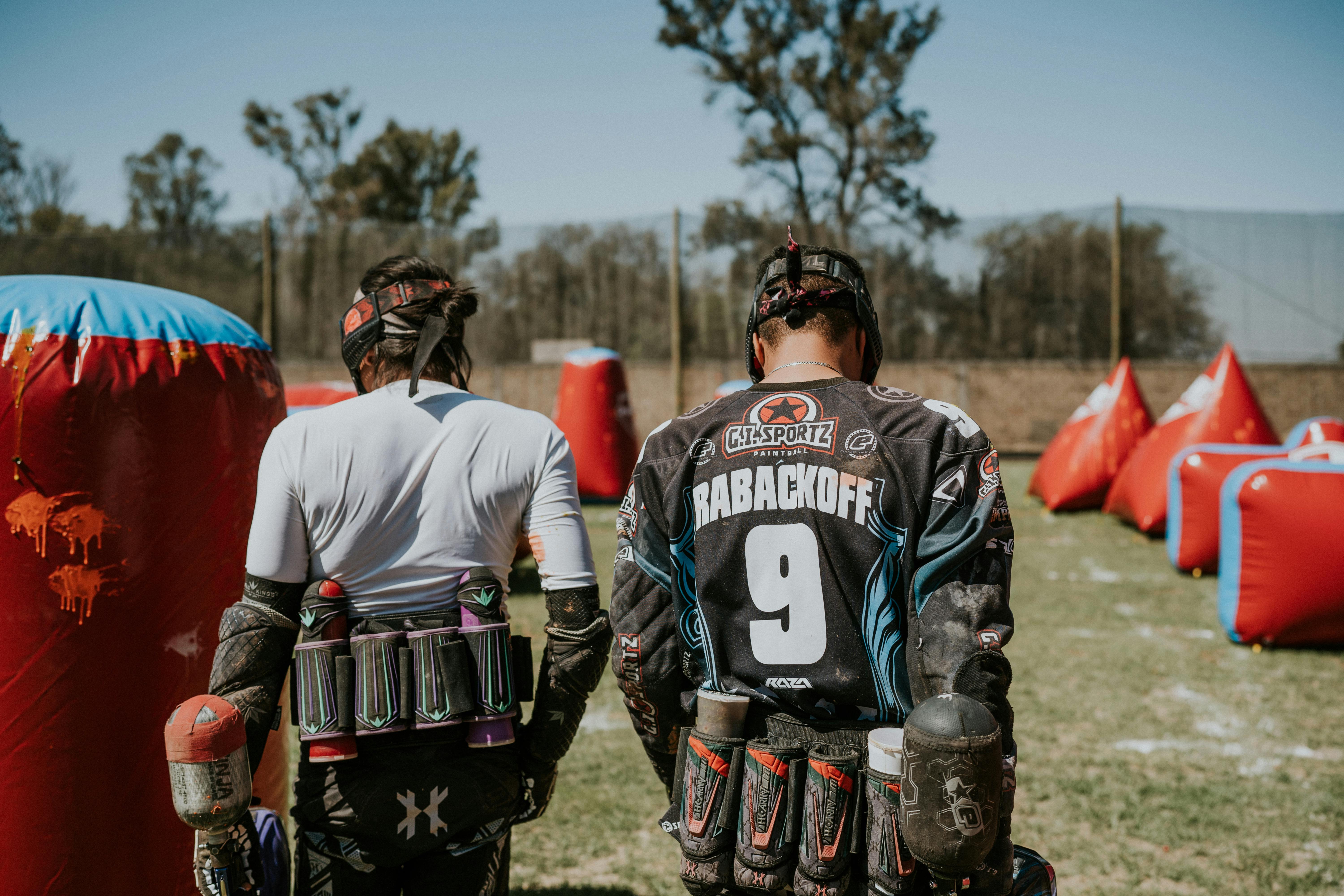 Two players in action on a paintball field, equipped and ready for the game. Prescription Goggle Inserts - Two players in action on a paintball field, equipped and ready for the game.