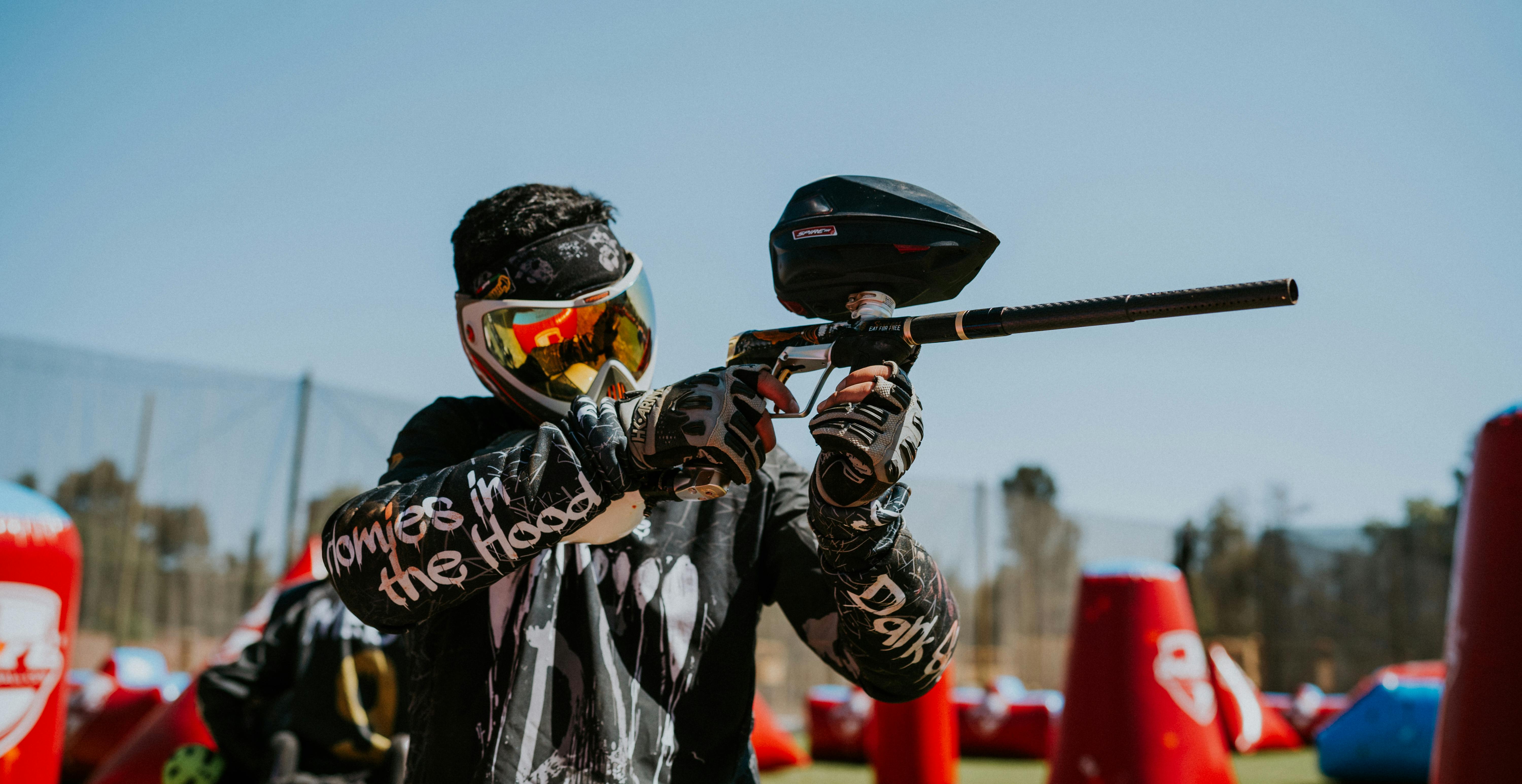 Adult engaged in an intense outdoor paintball match with protective gear and paintball gun. Prescription Goggle Inserts - Adult engaged in an intense outdoor paintball match with protective gear and paintball gun.