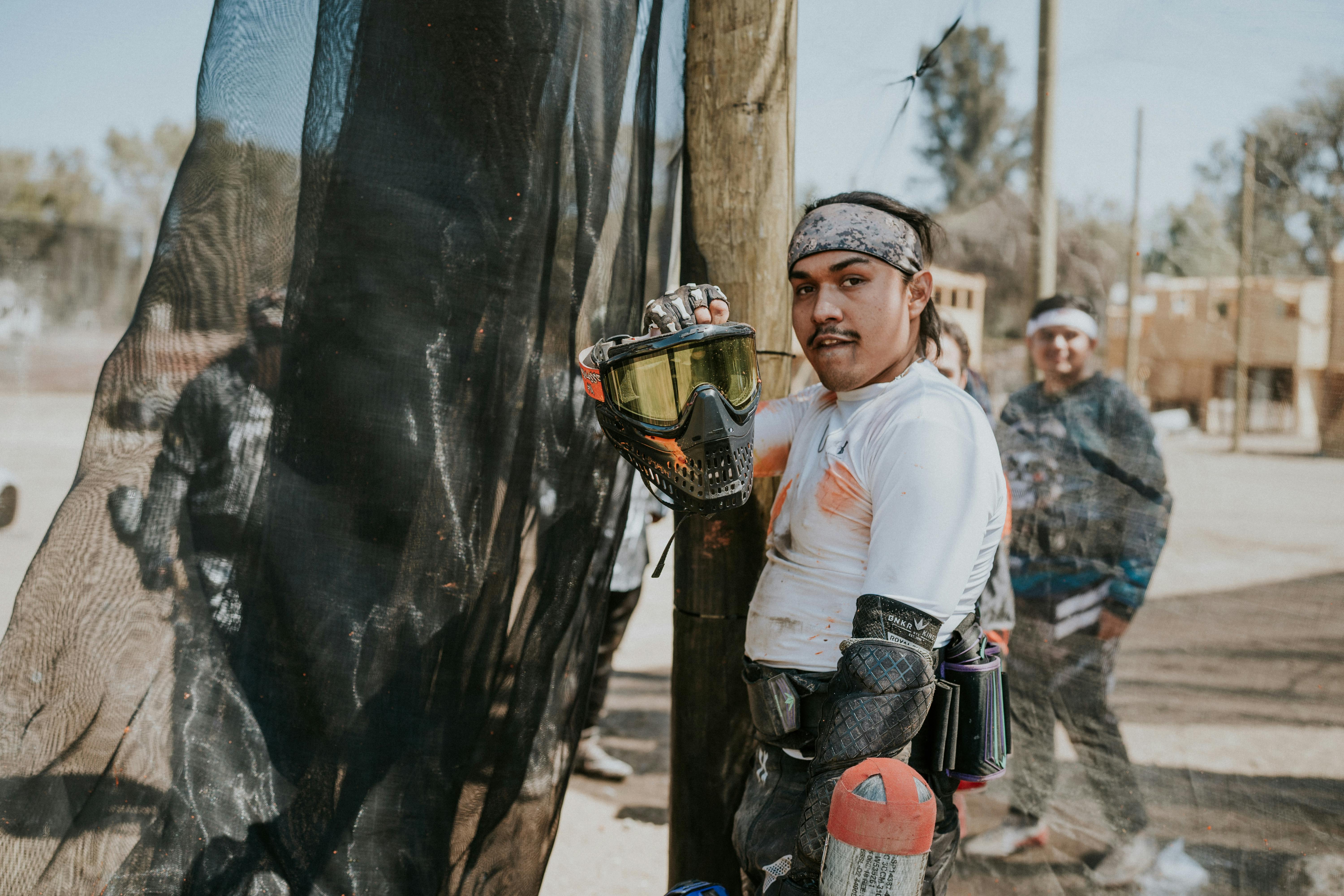 Group of men playing paintball outdoors, wearing protective gear and enjoying a sunny day. Prescription Goggle Inserts - Group of men playing paintball outdoors, wearing protective gear and enjoying a sunny day.