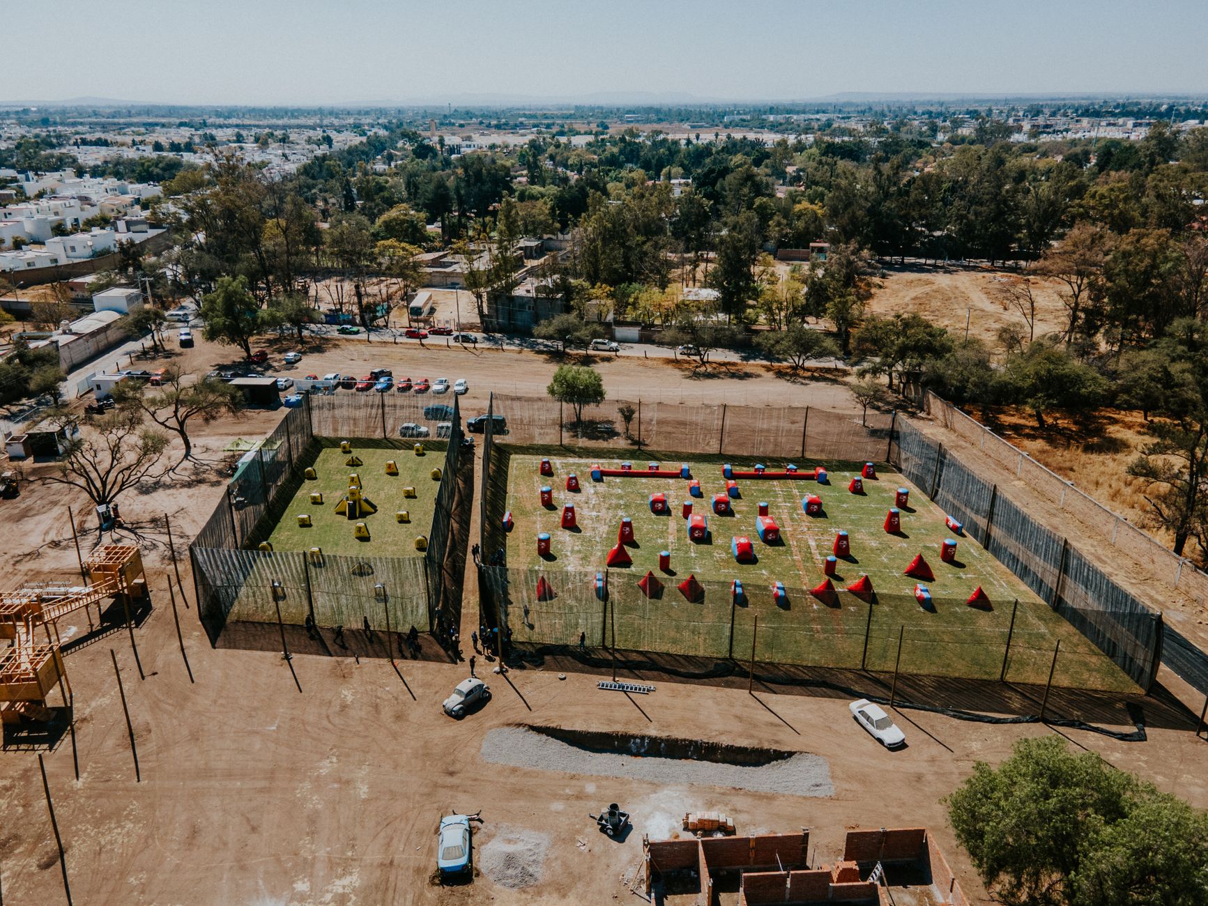 Aerial view of paintball fields in León, Mexico with surrounding urban landscape.