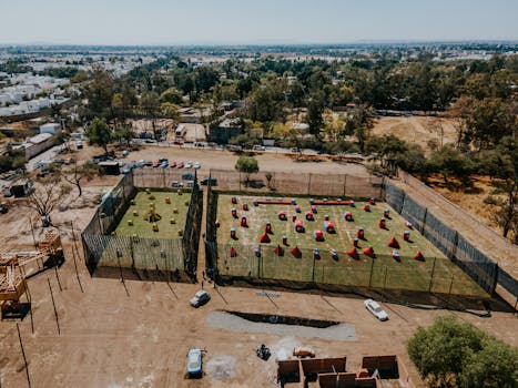 Aerial view of paintball fields in León, Mexico with surrounding urban landscape.