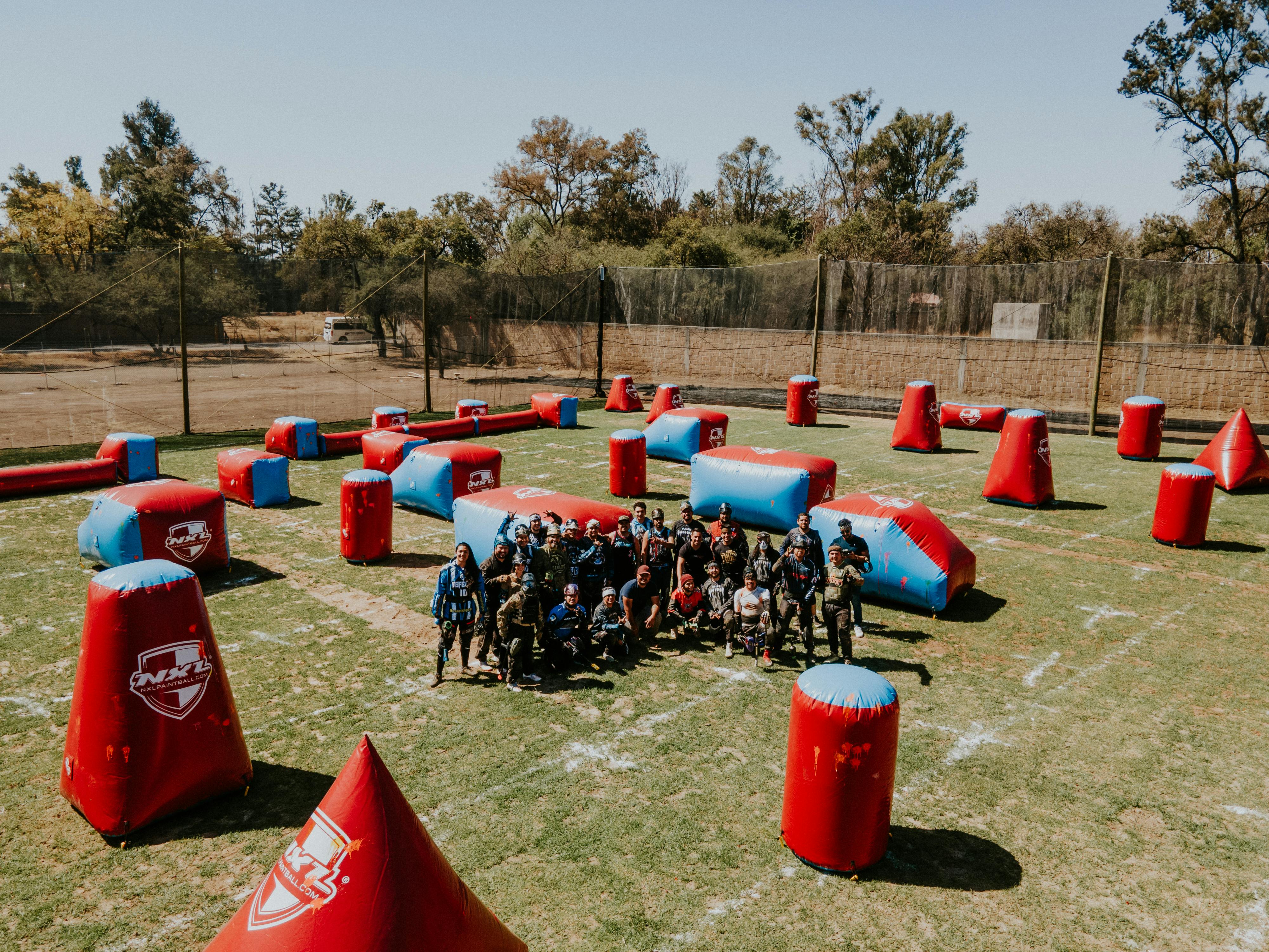 Eine Gruppe Erwachsener spielt Paintball auf einem aufblasbaren Feld in León, Mexiko. Prescription Goggle Inserts - Group of adults playing paintball on an inflatable field in León, Mexico.