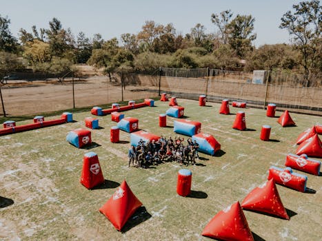 Paintball group playing on a sunny day in León, Mexico. Vibrant inflatable barriers fill the field.