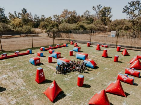 Aerial shot of a vibrant outdoor paintball field in León, Mexico, with players ready for action.