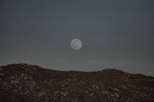Free Capture of the full moon rising over a mountain in Valle de Guadalupe, Mexico. Stock Photo