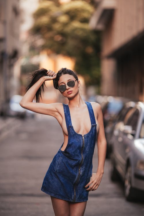 Young, Topless Woman Wearing a Dress and Sunglasses, Posing on a Street in City 