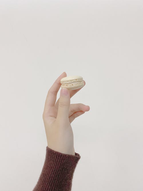 Free Hand Holding a White Macaron Stock Photo