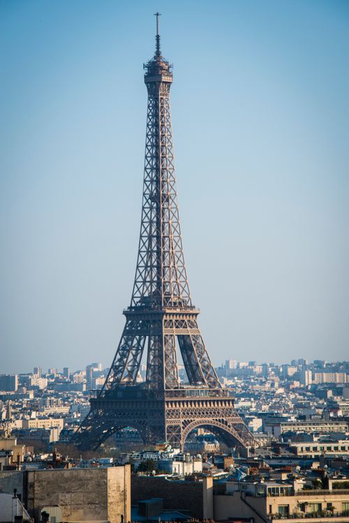 Free Iconic Eiffel Tower standing tall under a clear blue sky in Paris. Stock Photo