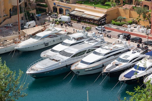 Aerial view of luxury motor yachts moored at a beautiful marina with vibrant surroundings.