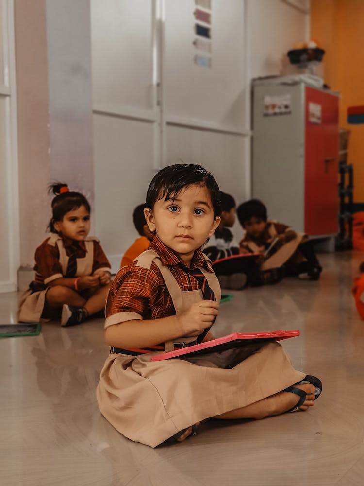 Girl Wearing A School Uniform Sitting On The Floor