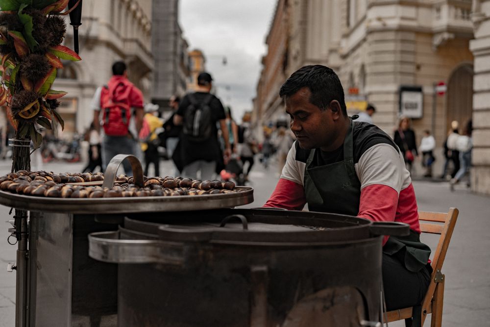 Vânzător de castane coapte pe o stradă aglomerată din Roma