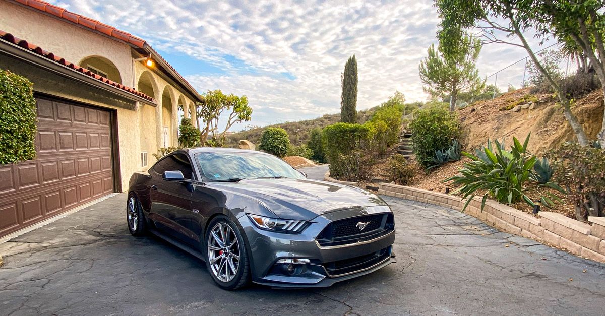 A sleek gray Mustang parked in a scenic driveway in San Marcos, California.
