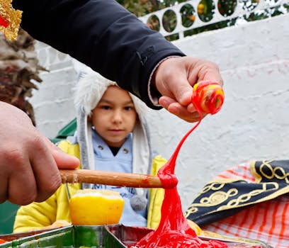 A child watches the intricate making of colorful traditional Turkish candy on an outdoor street setup.