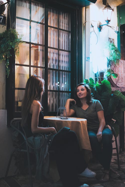 Free Two Women Sitting and Chatting Near Table Stock Photo