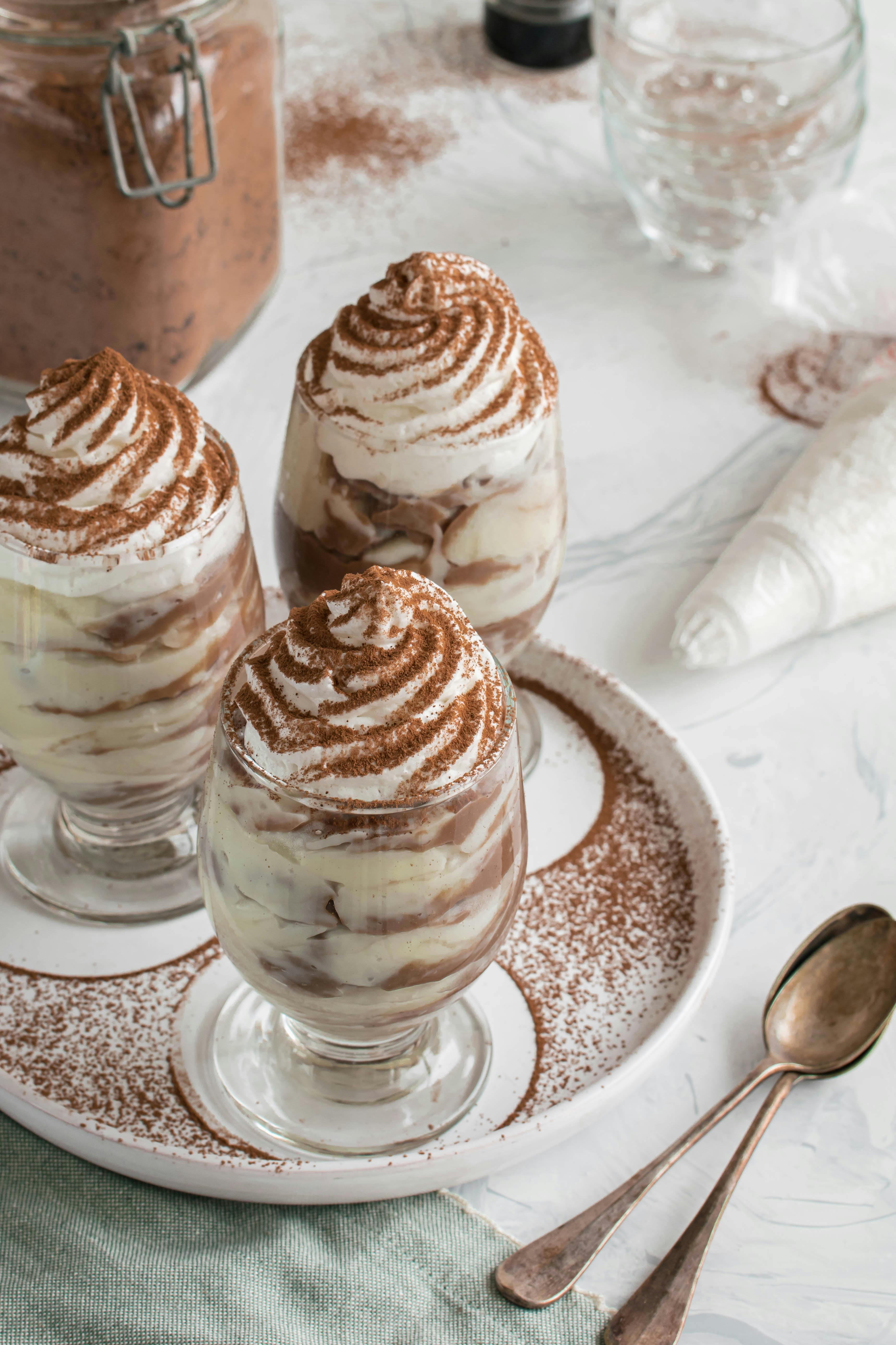 photo of three creamy desserts in a glasses covered in chocolate powder
