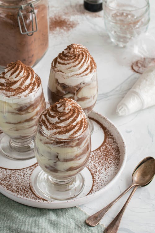 Photo of Three Creamy Desserts in a Glasses Covered in Chocolate Powder