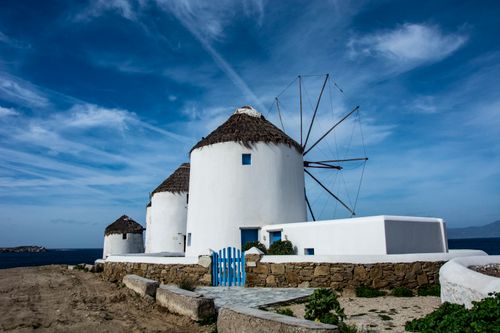Free Scenic view of iconic white windmills against a blue sky in Mykonos, Greece. Stock Photo