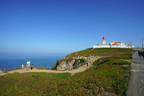 Wide Angle Photo of Lighthouse Under Blue Sky