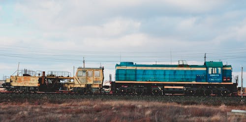 田野旁邊的藍色和棕色火車
