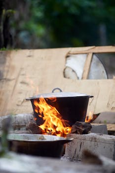 An outdoor pot cooking over an open flame, capturing the essence of rustic outdoor cooking.