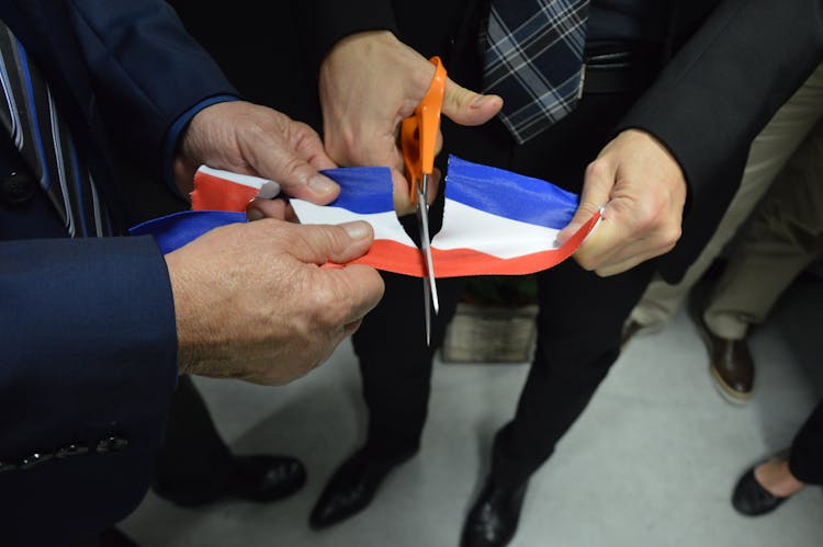 Man Cutting Multi Colored Ribbon