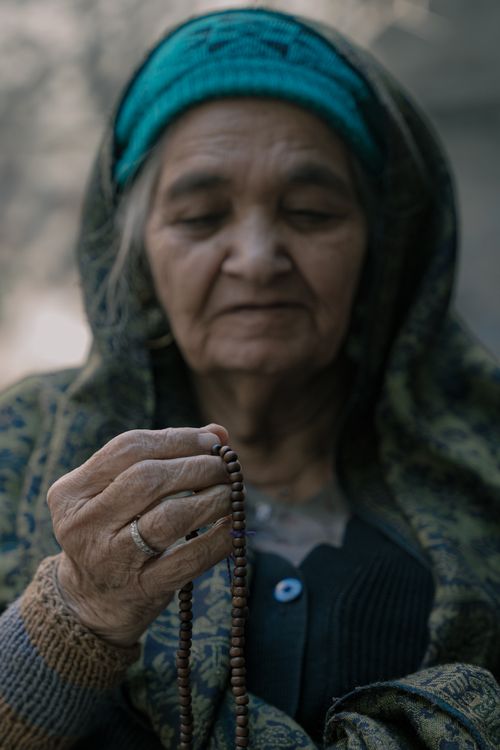 Free An elderly woman holding prayer beads in a peaceful moment. Stock Photo