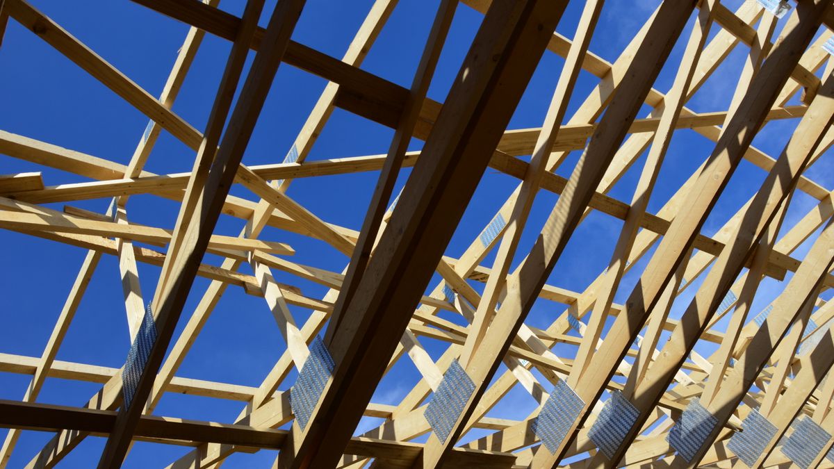 Roof trusses over an open attic. Blown-in insulation fills around truss webs and wiring that batts would leave gaps around.