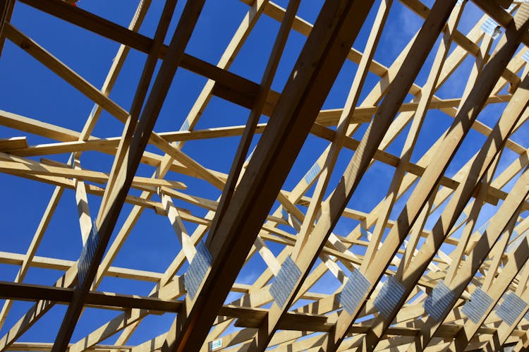 Wooden Skeletal Structure Of Roof Under Blue Sky