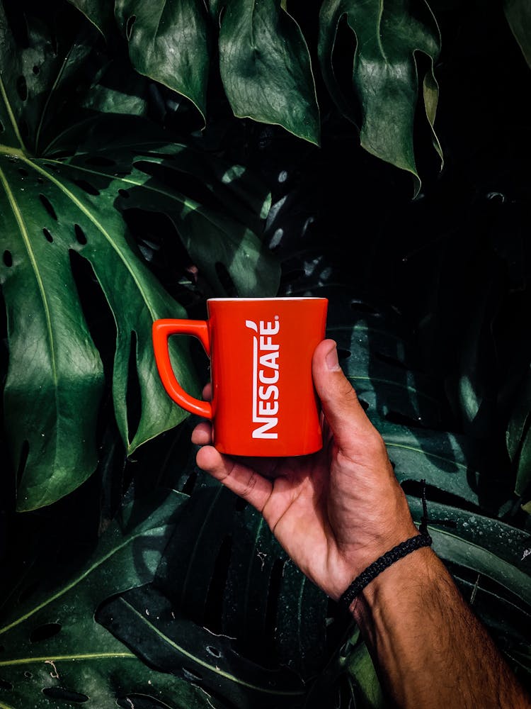 Photo Of Man Holding A Red Nescafe Mug