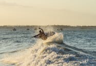 日出时分，冲浪者迎着海浪，熟练地驾驭着充满活力的浪花