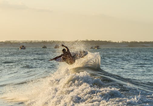 日出时分，冲浪者迎着海浪，熟练地驾驭着充满活力的浪花