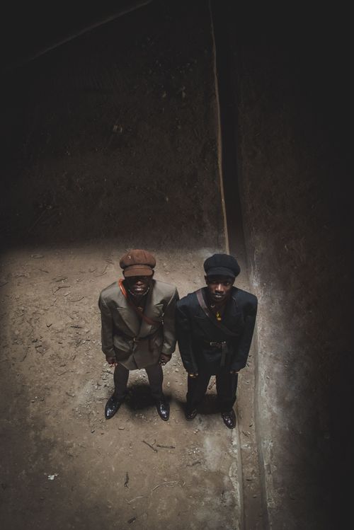 Free Retro fashion portrait of two men in vintage attire, shot from above in Nairobi's urban setting. Stock Photo